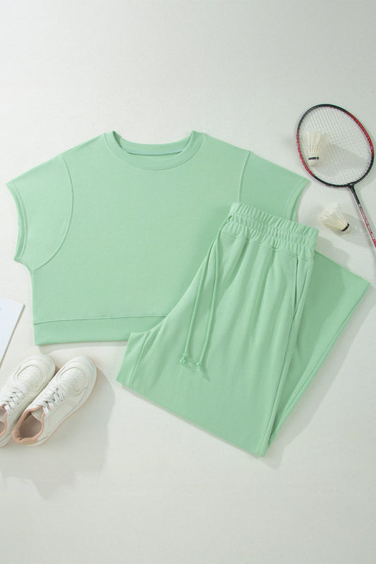 Mint green sleeveless top and pants with a badminton racket on a light gray background