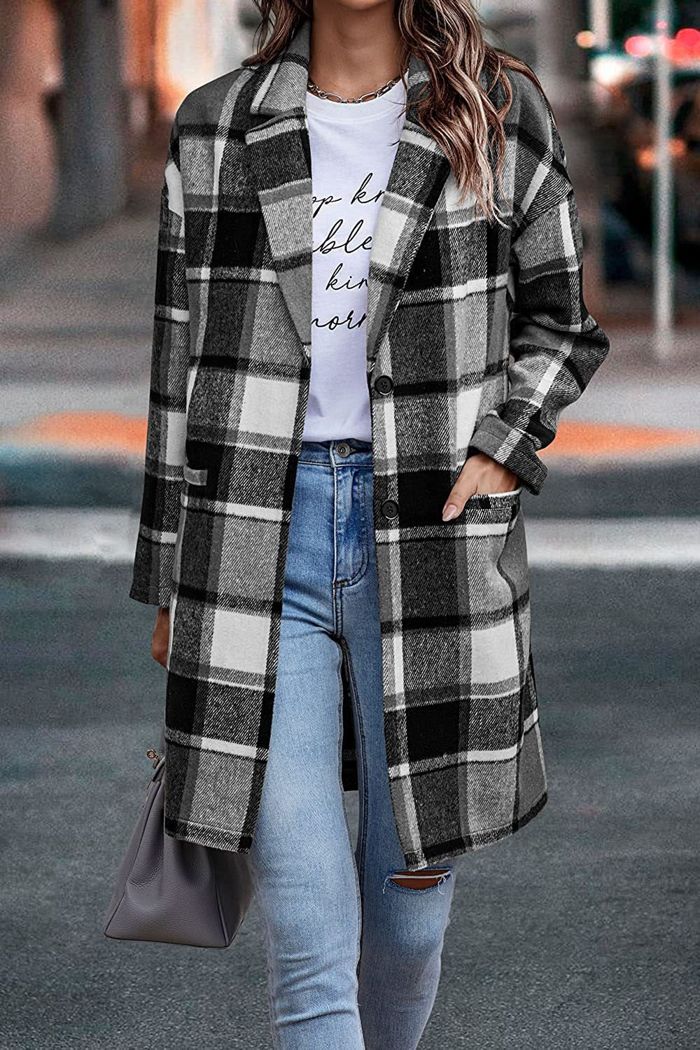 Person wearing a plaid coat and jeans on a city street.