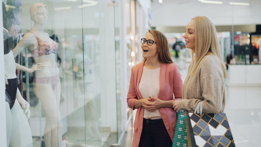 Two women looking at a store mannequin