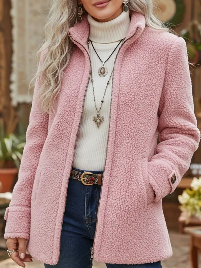 Person wearing a pink sherpa coat with a blurred background