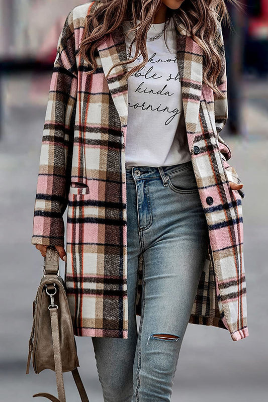 Person wearing a plaid coat, white graphic t-shirt, and ripped jeans with a blurred background