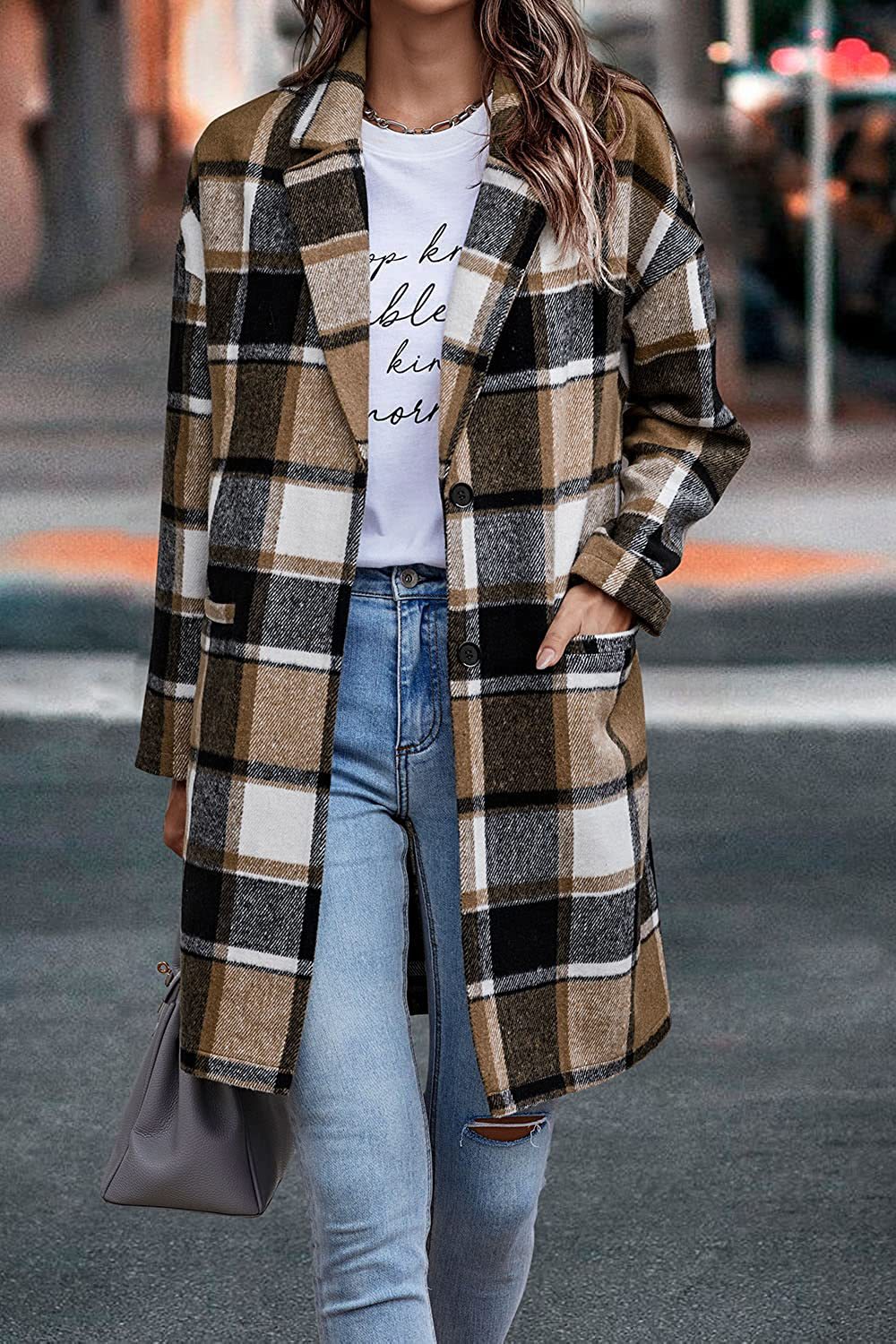 Person wearing a plaid coat, white t-shirt, and blue jeans on a street.