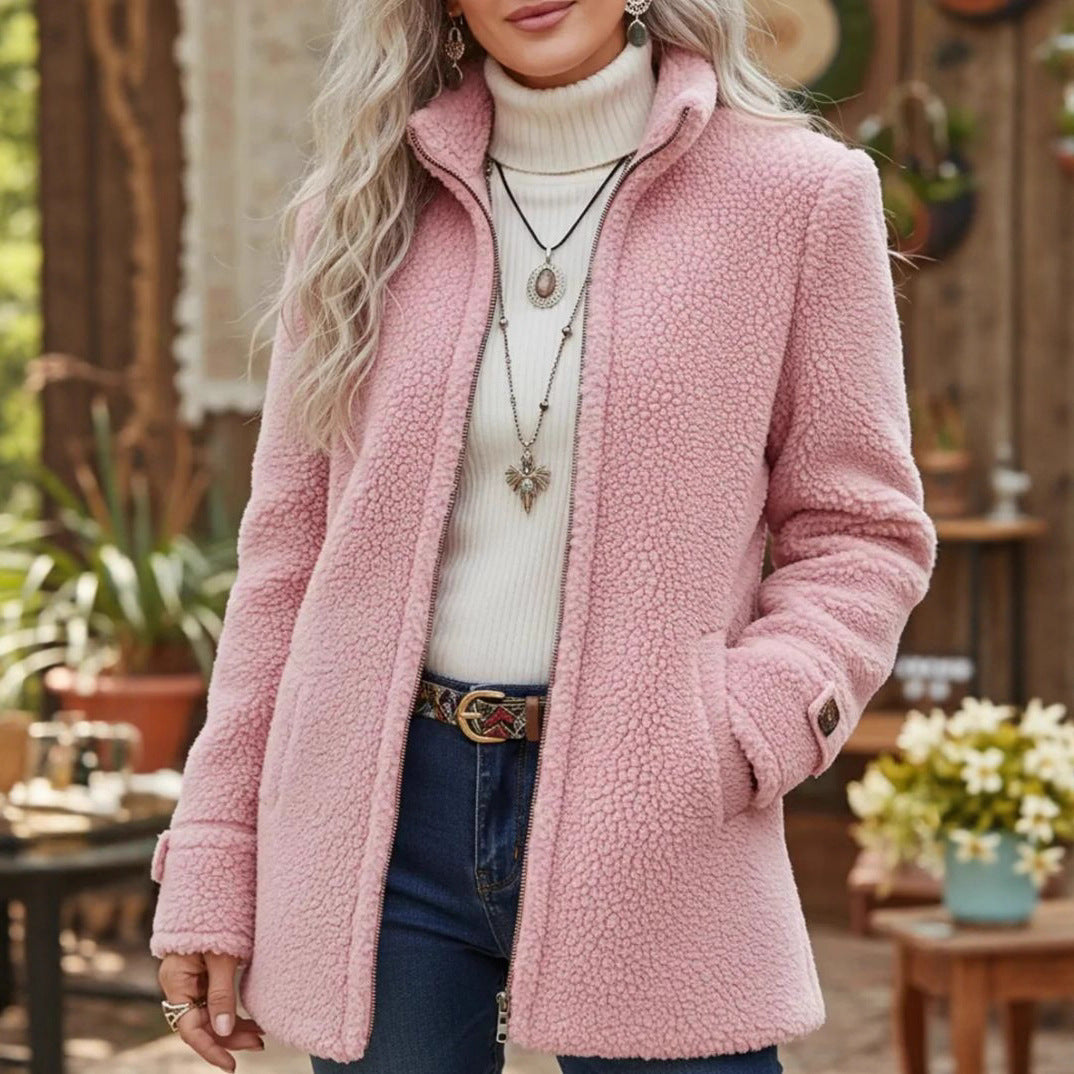 Person wearing a pink sherpa coat outdoors with plants and furniture in the background