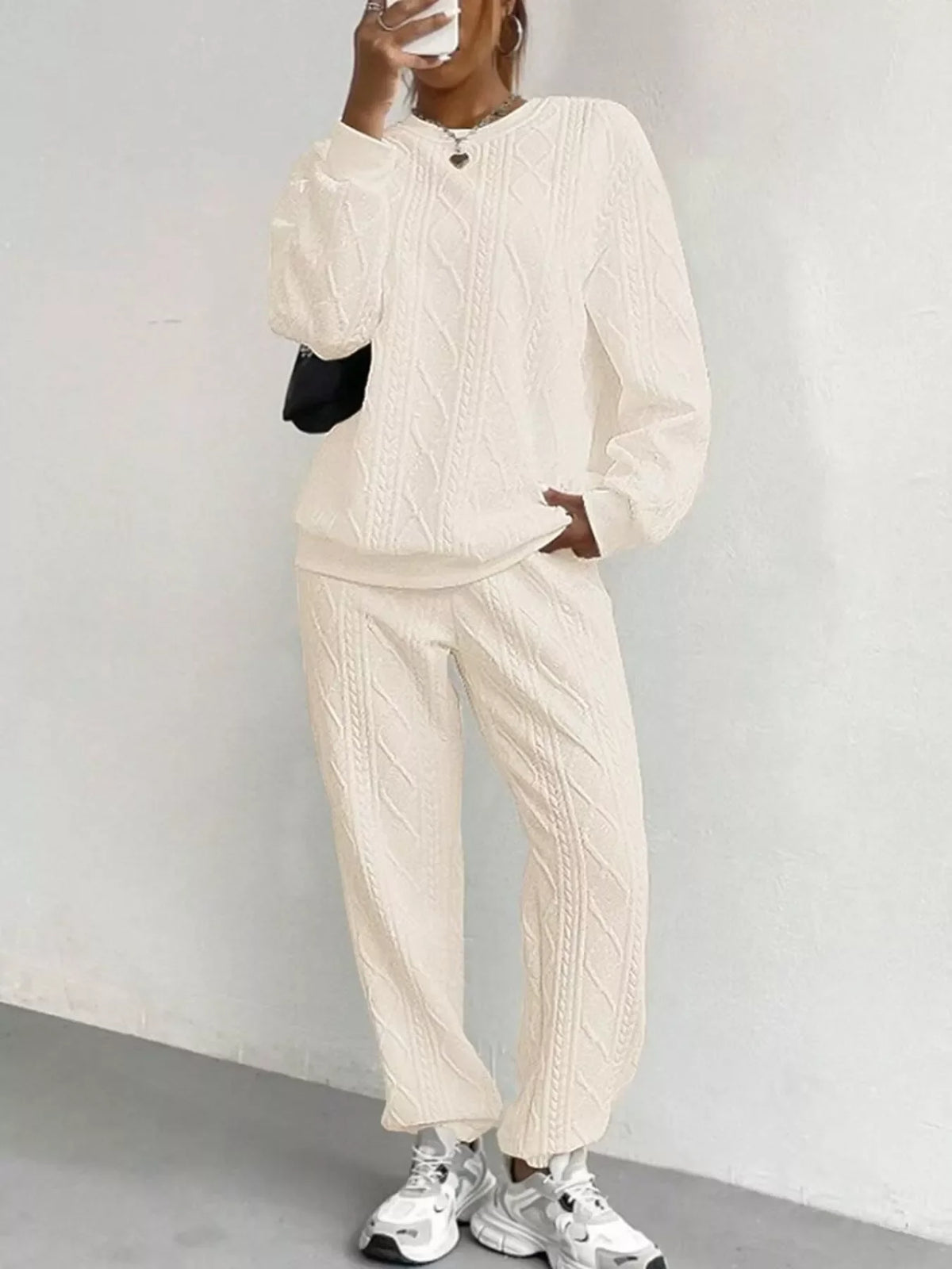 Person wearing a beige tracksuit against a plain background