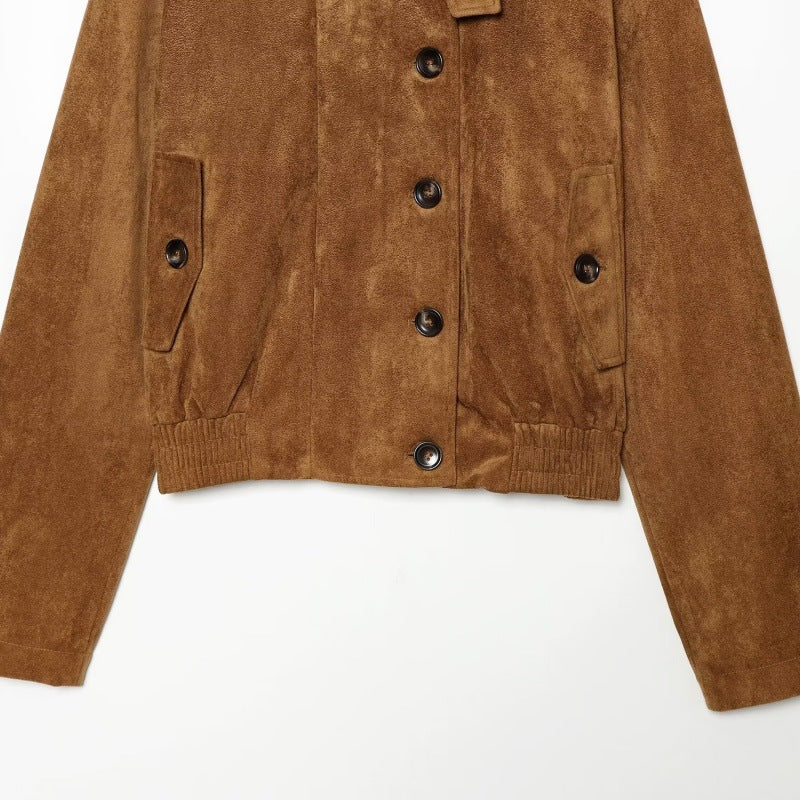 A cropped brown suede jacket with a button front, side pockets, and ribbed hem and cuffs, shown against a plain white background.