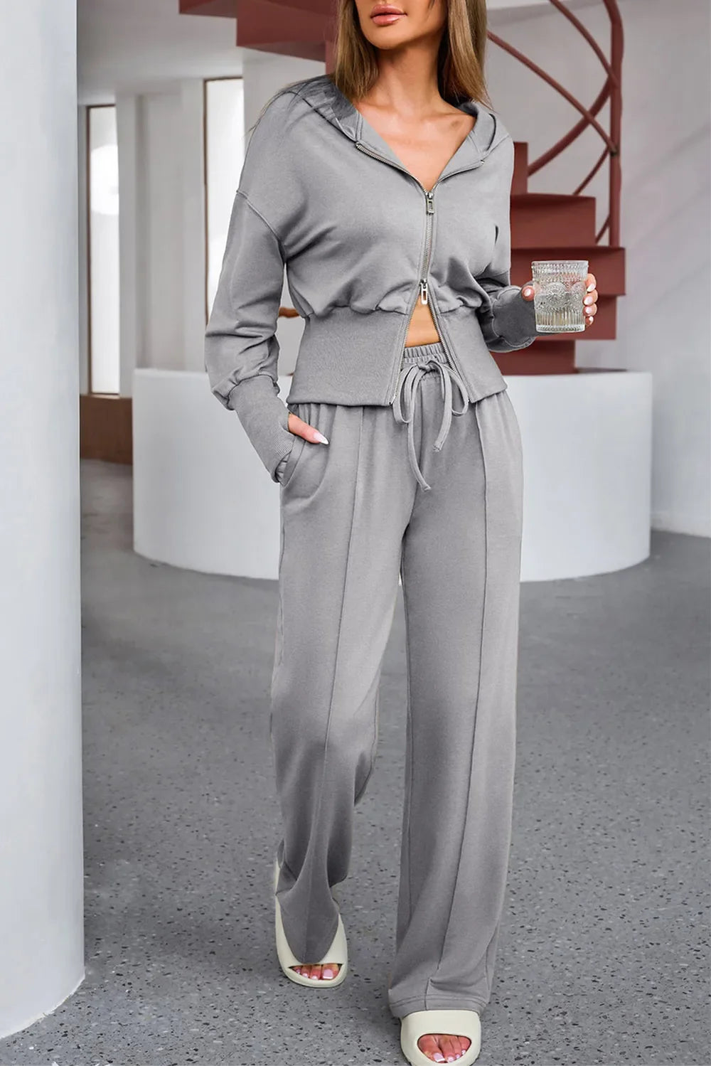 Woman wearing a gray tracksuit in an indoor setting
