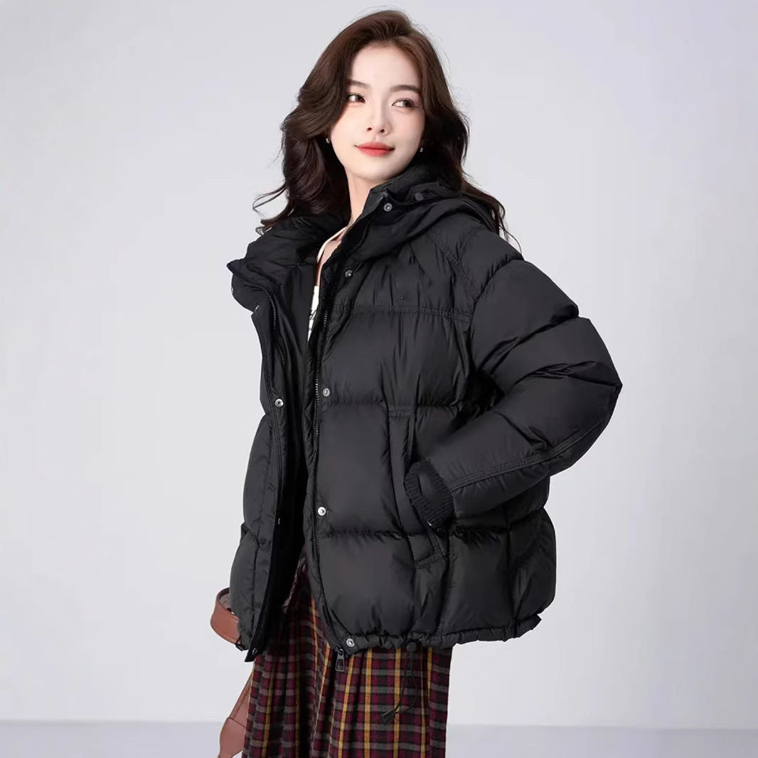 Woman wearing a black puffer jacket on a white background