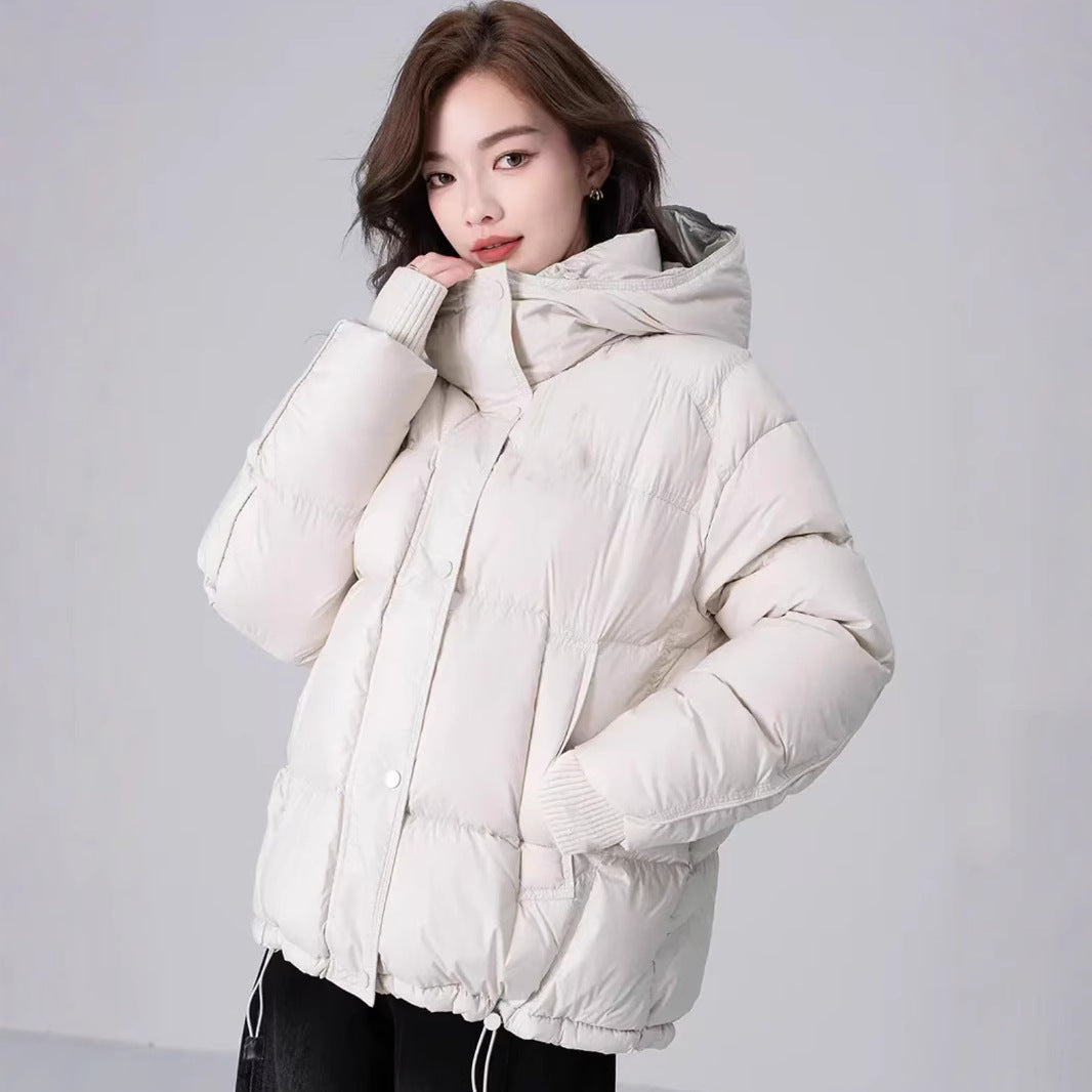 Woman wearing a white puffer jacket against a plain background
